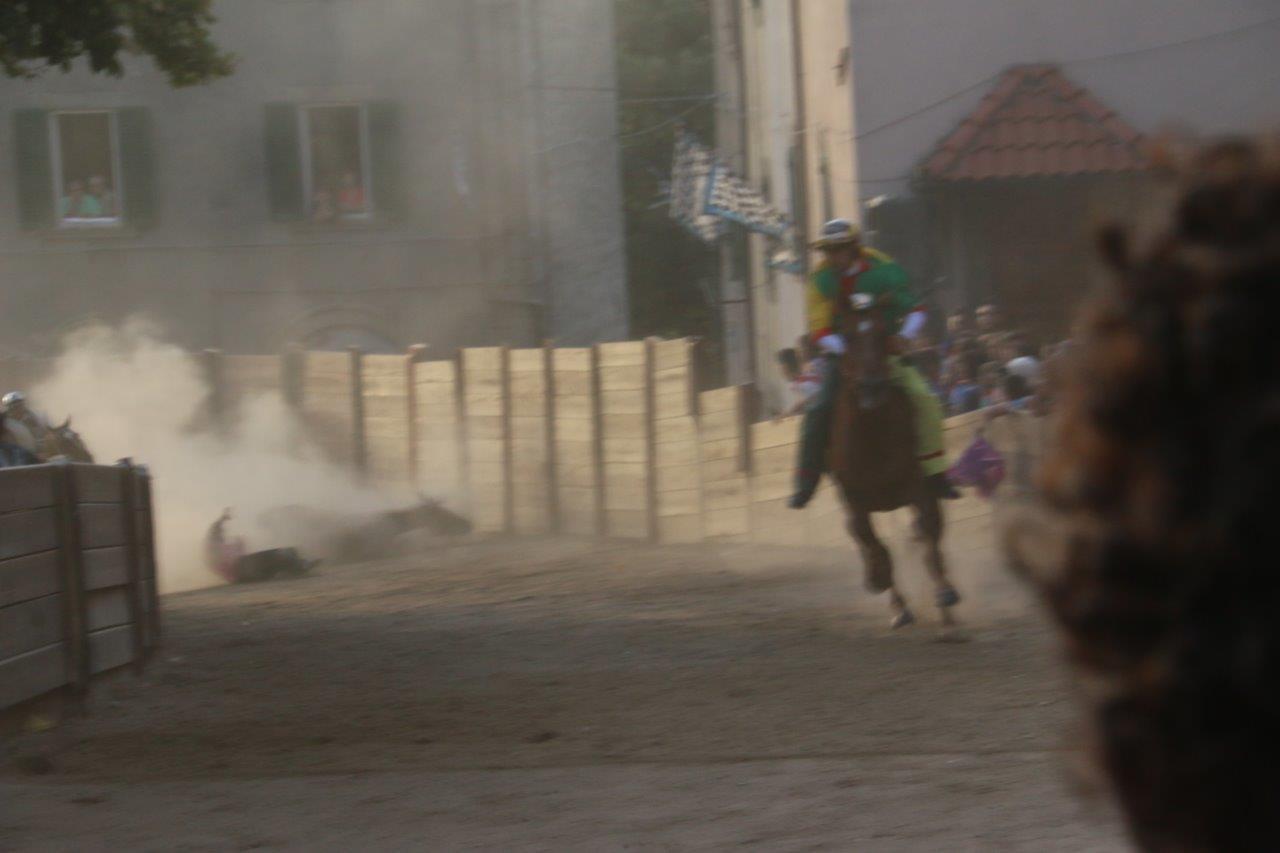 Sullo sfondo il fantino del Borgo, Antonio Siri, e il cavallo Quativoglio a terra. In primo piano Giuseppe Zedde del Poggio verso la vittoria (foto Russo) 