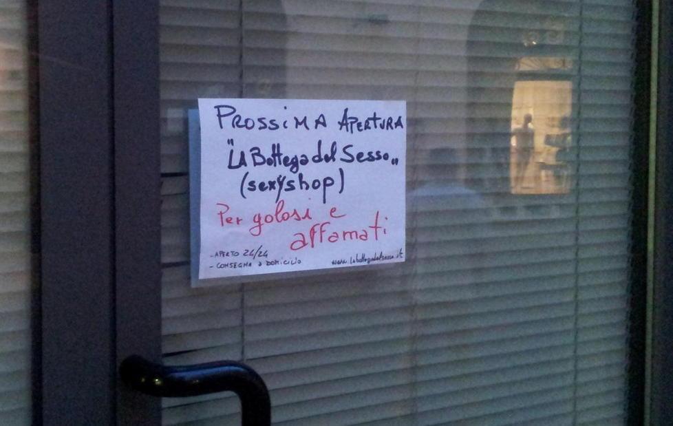 Il cartello affisso alla vetrina del negozio in allestimento