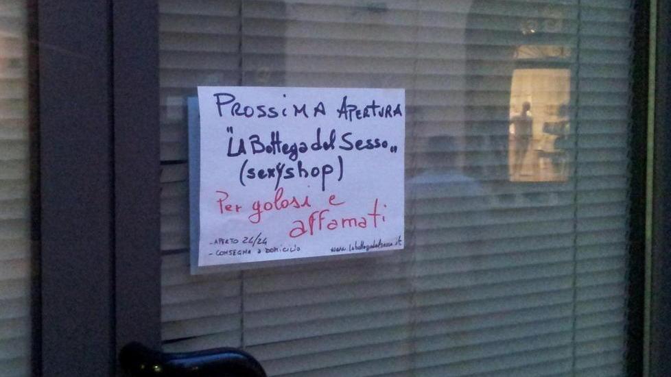 Il cartello affisso alla vetrina del negozio in allestimento