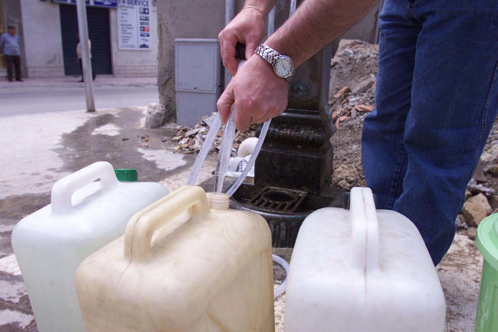 Un cittadino con le taniche ad una fontana (foto d'archivio)