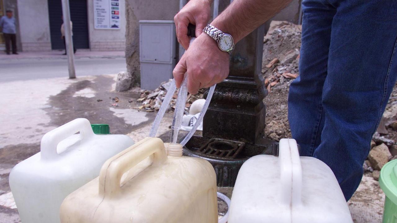 Un cittadino con le taniche ad una fontana (foto d'archivio)