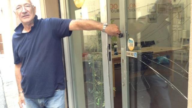 Un iscritto mostra la vetrina rotta e la serratura forzata (foto Batavia)