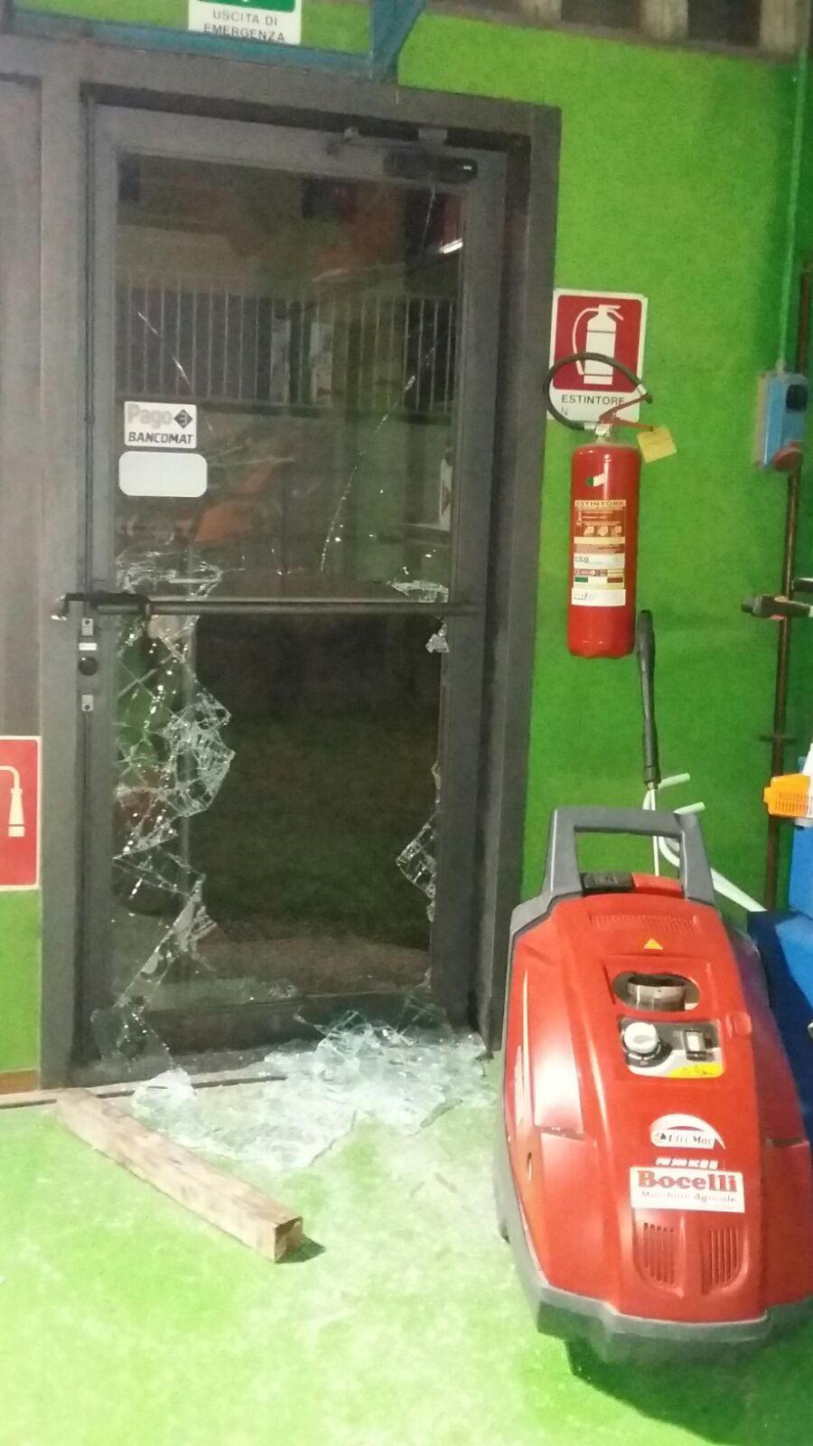 La porta danneggiata con i vetri in frantumi e uno degli attrezzi che i ladri hanno tentato di portare via
