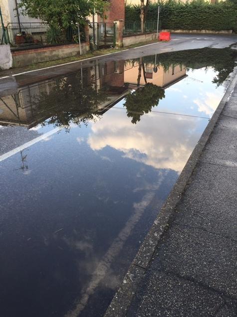 La pioggia forma un “lago” nel parcheggio delle scuole