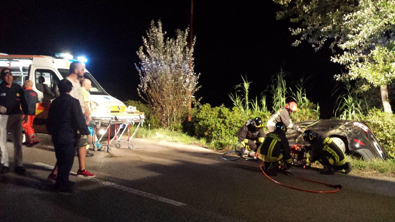 I vigili del fuoco al lavoro intorno alla macchina finita nel fosso