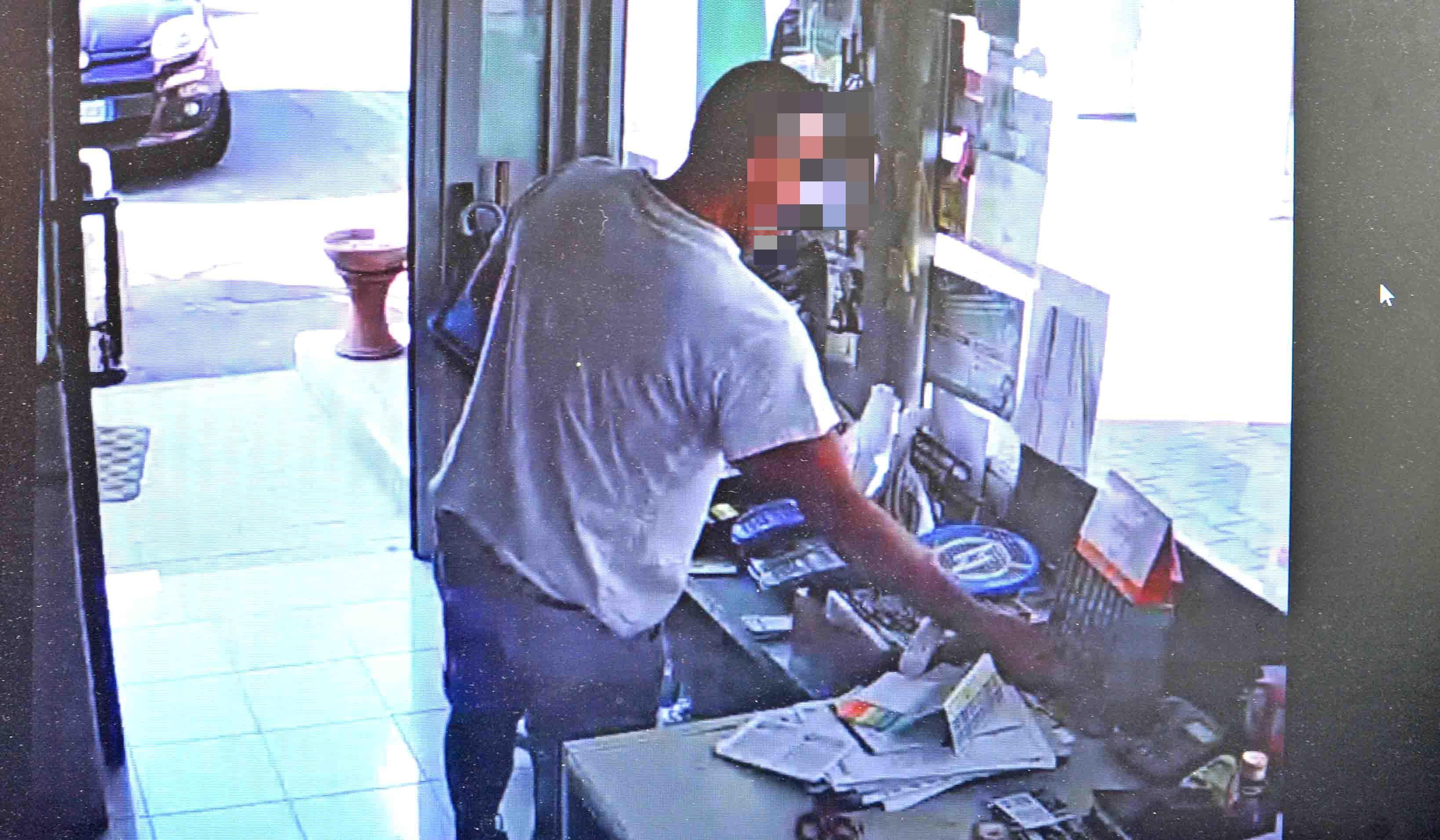 Nel fermo-immagine ripreso da un video della telecamera del distributore si vede l’uomo in azione