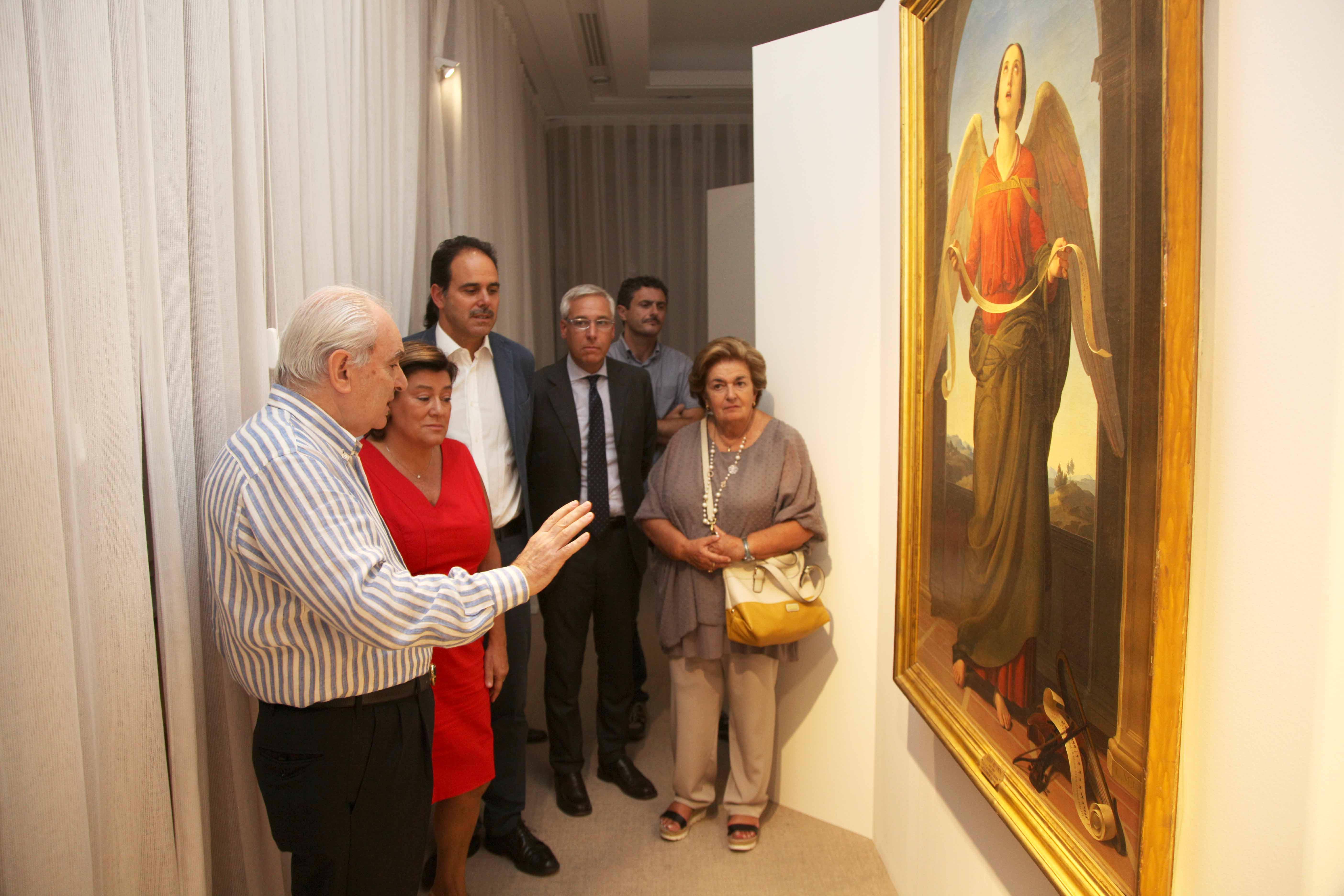 Giuliano Matteucci mentre illustra un'opera in esposizione alla delegazione che ha visitato la mostra su Silvestro Lega