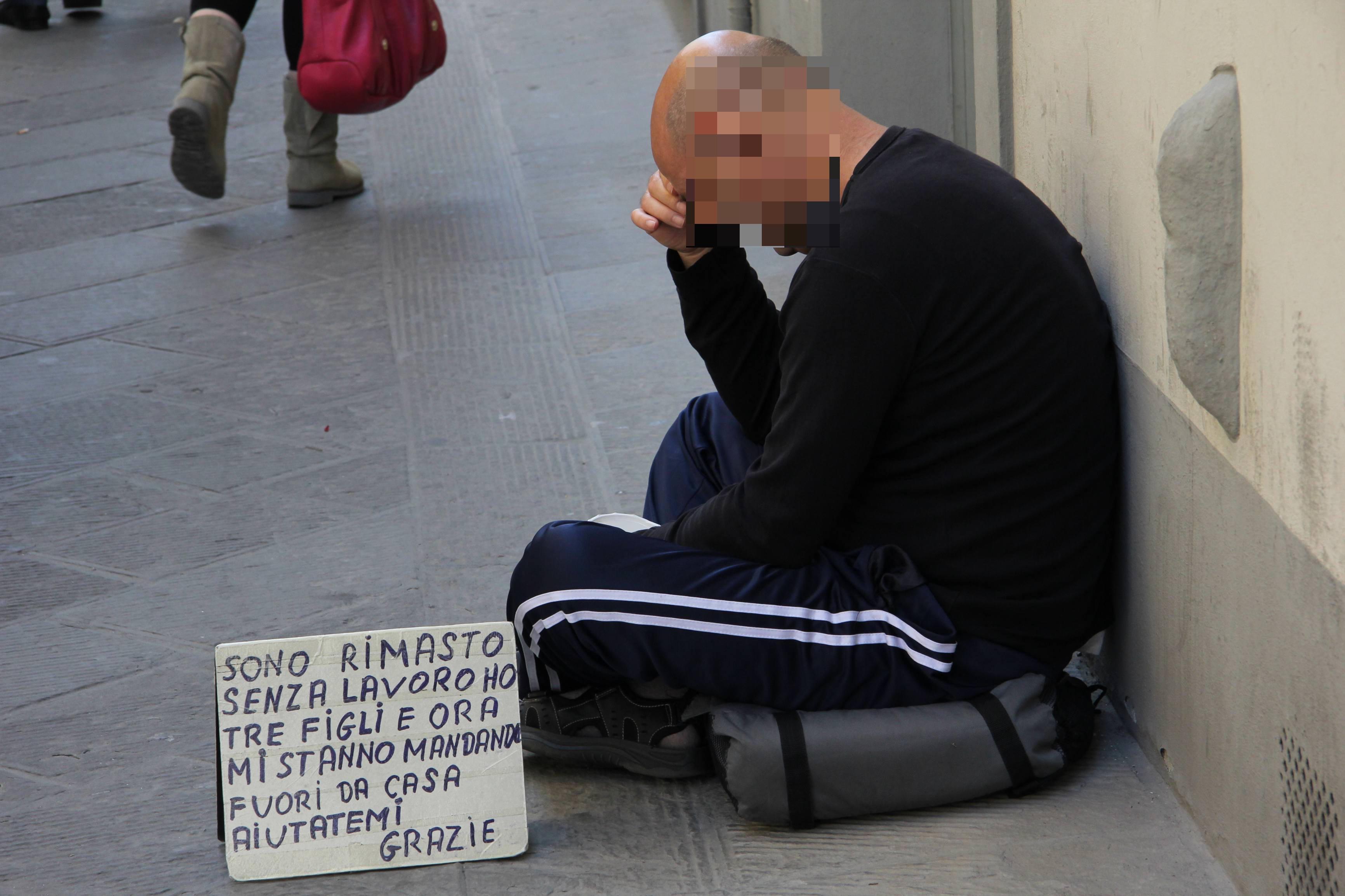 Un uomo chiede l'elemosina in centro a Prato (foto Batavia)
