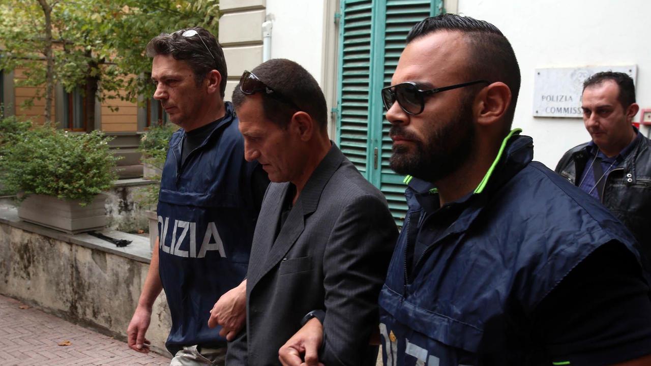 Uno degli arrestati mentre viene scortato fuori dal commissariato (Foto Nucci)