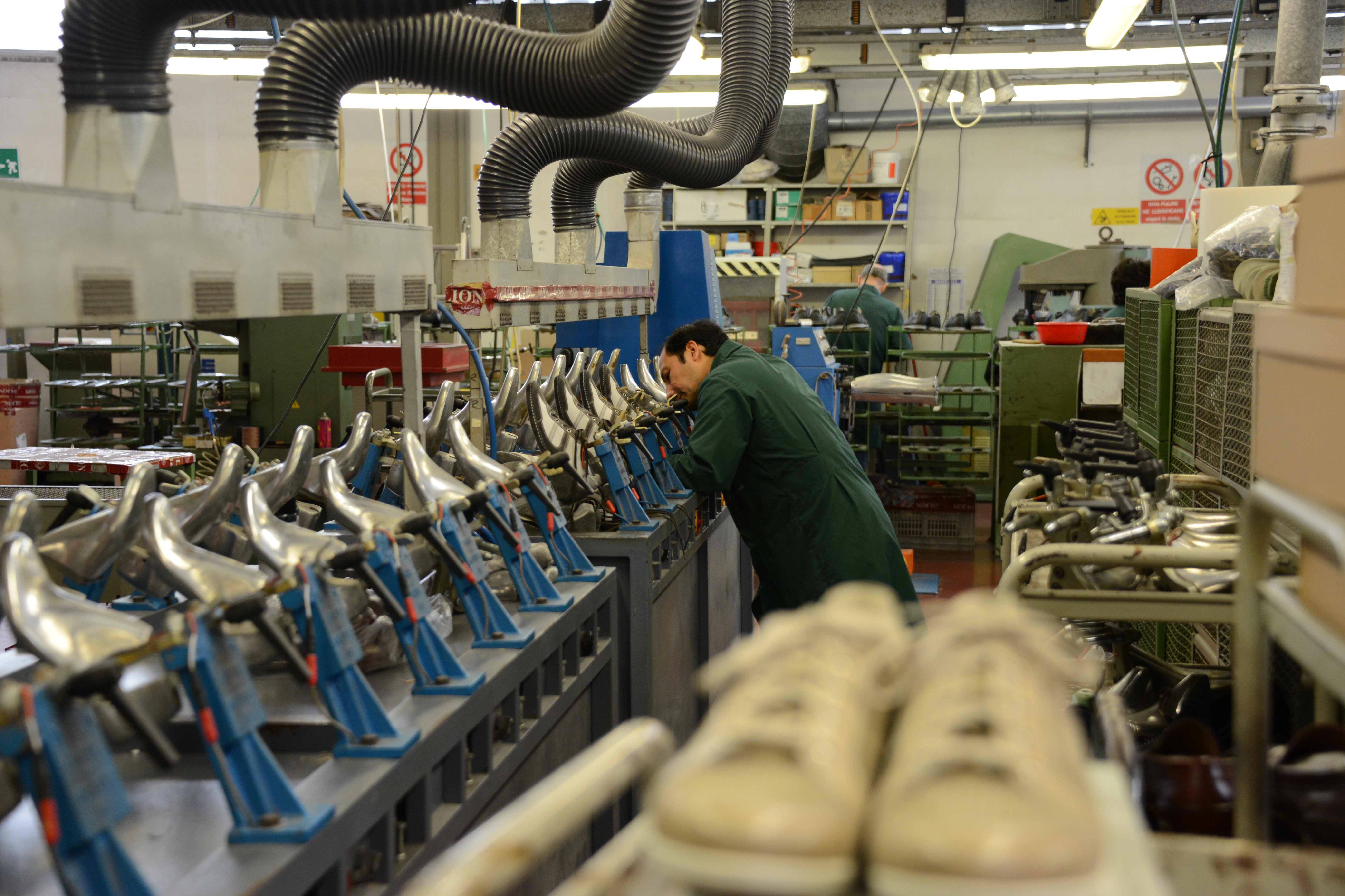 Un operaio al lavoro in un calzaturificio (foto d'archivio)