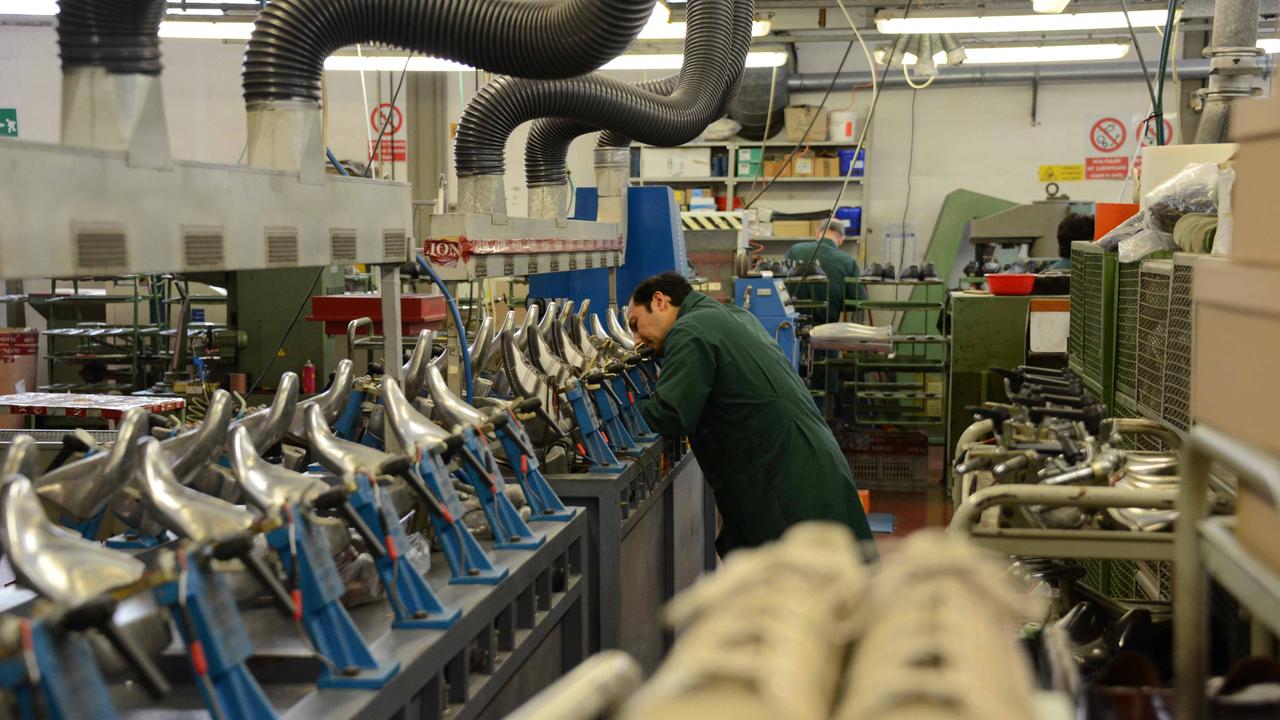 Un operaio al lavoro in un calzaturificio (foto d'archivio)