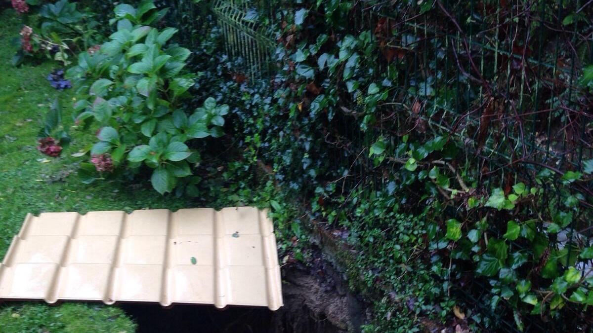 La voragine che si è aperrta nel giardino privato dopo il cedimento della sponda del Pesato Saracino