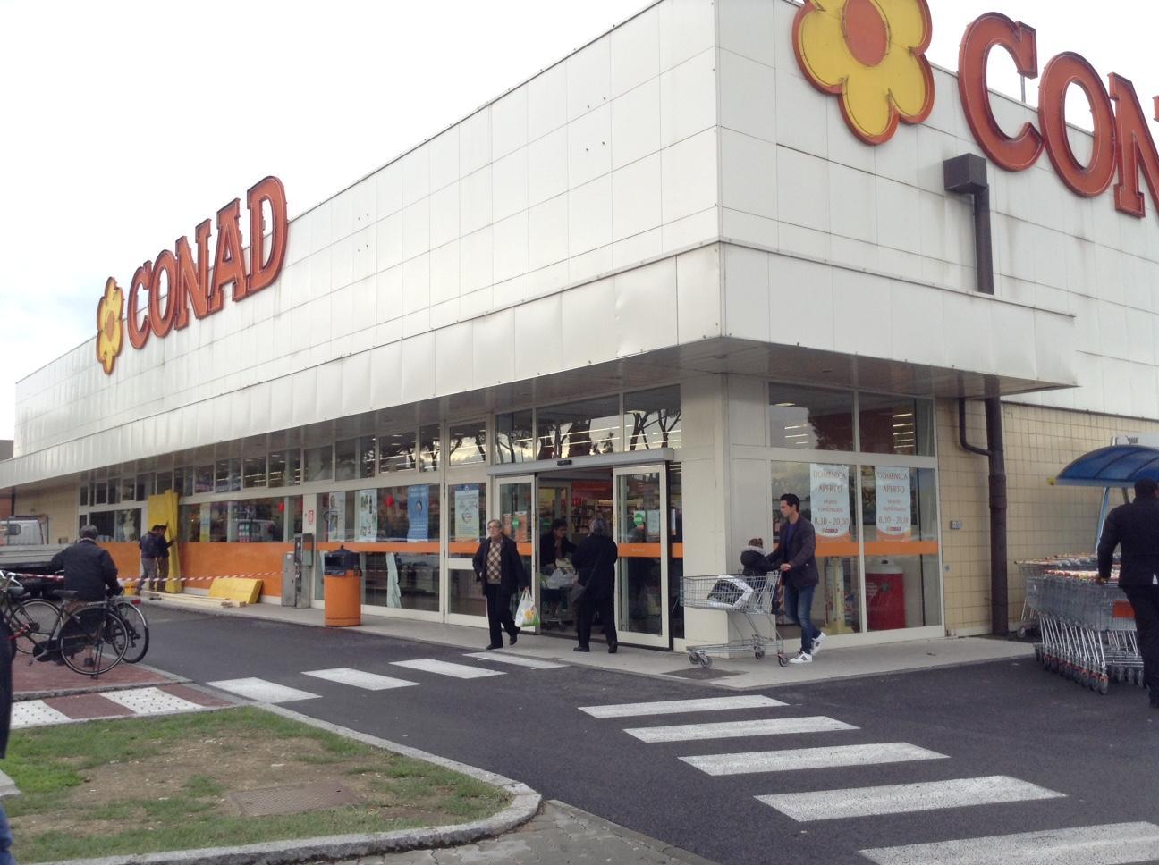 Operai riparano la vetrata del supermercato Conad