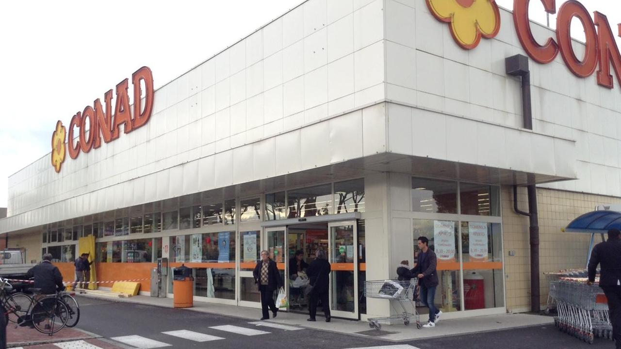 Operai riparano la vetrata del supermercato Conad