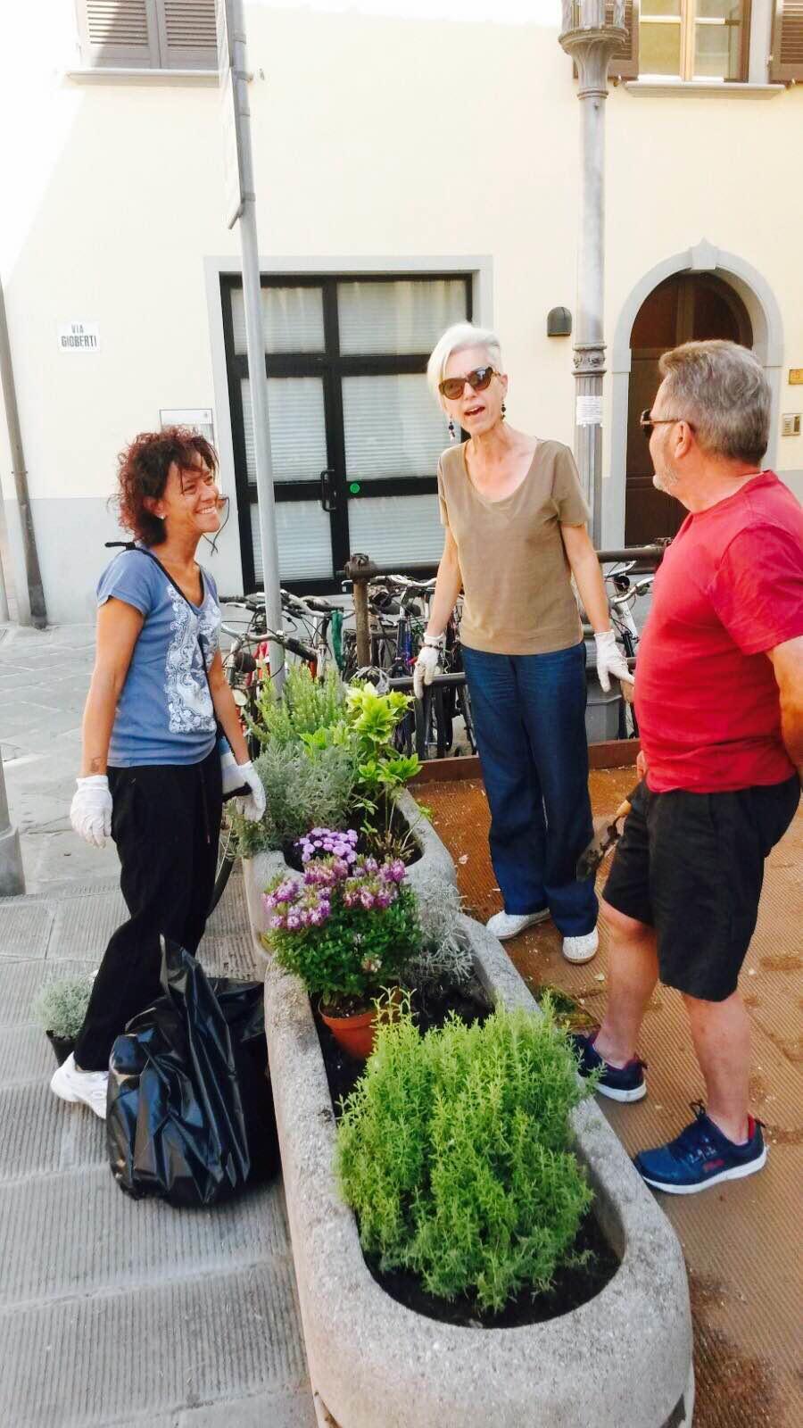 Cittadini si prendono cura di un'aiuola