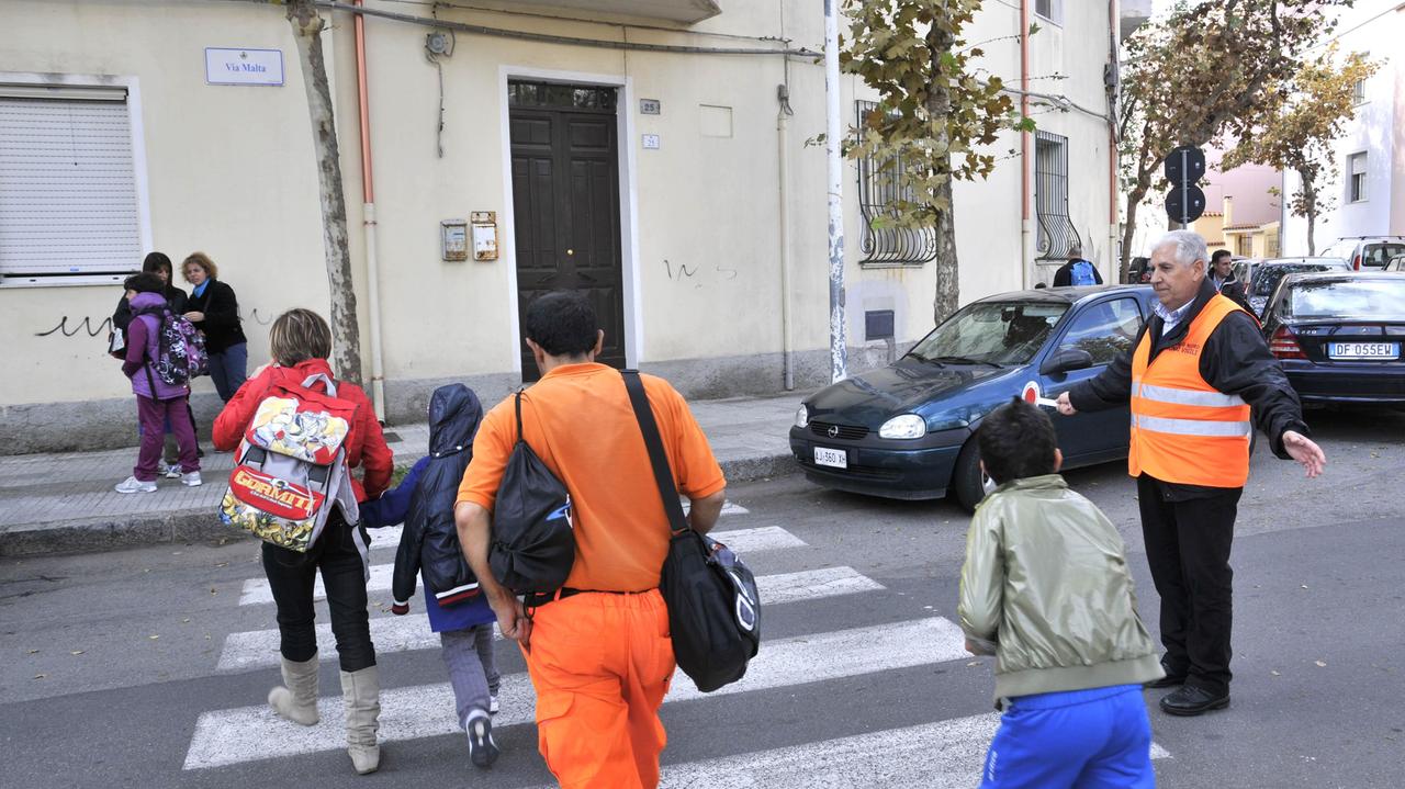 Un nonno vigile in servizio davanti a una scuola