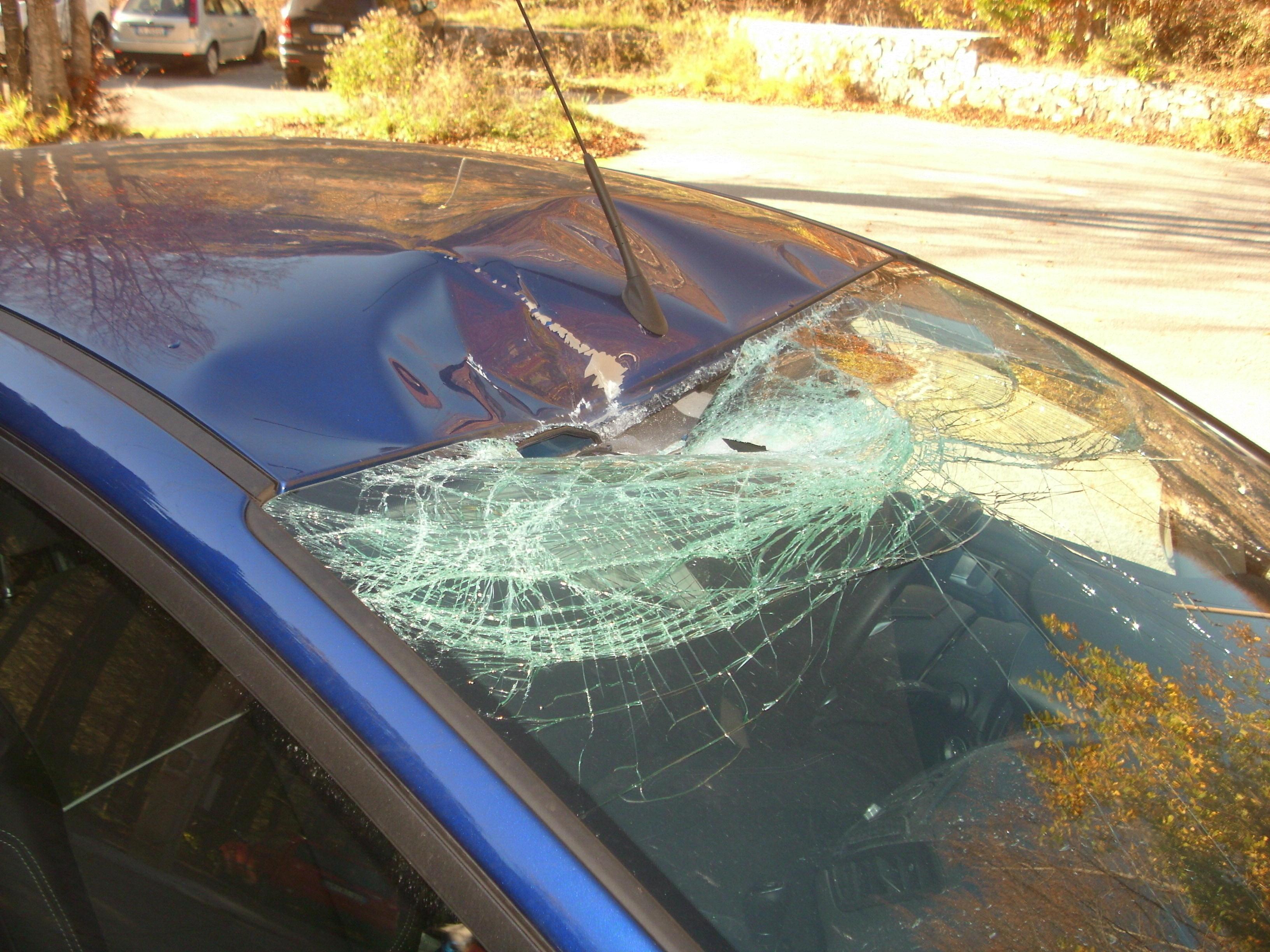 Il vetro dell'auto distrutto dal masso