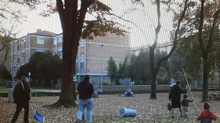 Famiglie coi rastrelli per raccogliere le foglie