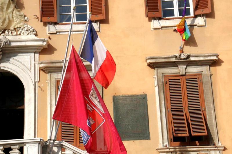 La bandiera del Comune esposta a mezz'asta di fianco a quella francese (Marzi Pentafoto)