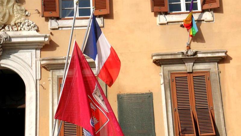 La bandiera del Comune esposta a mezz'asta di fianco a quella francese (Marzi Pentafoto)