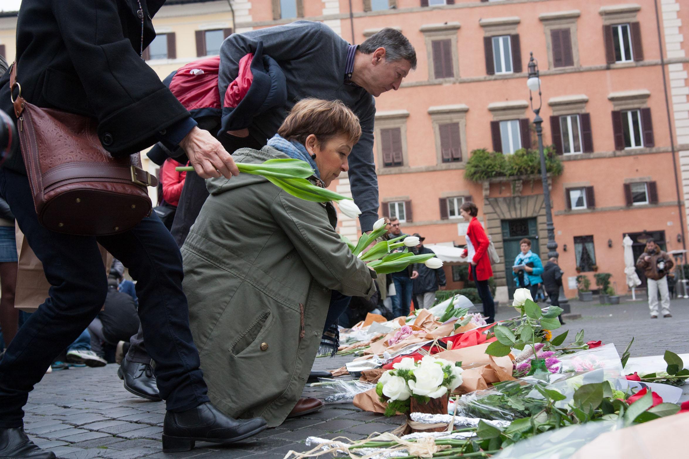 Due ferraresi depositano  fiori davanti all'ambasciata francese a Roma