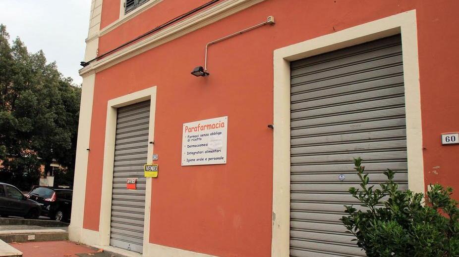 La parafarmacia di viale Fedeli con affissi i cartelli “affittasi fondo” e “cedesi attività” (foto Nucci)