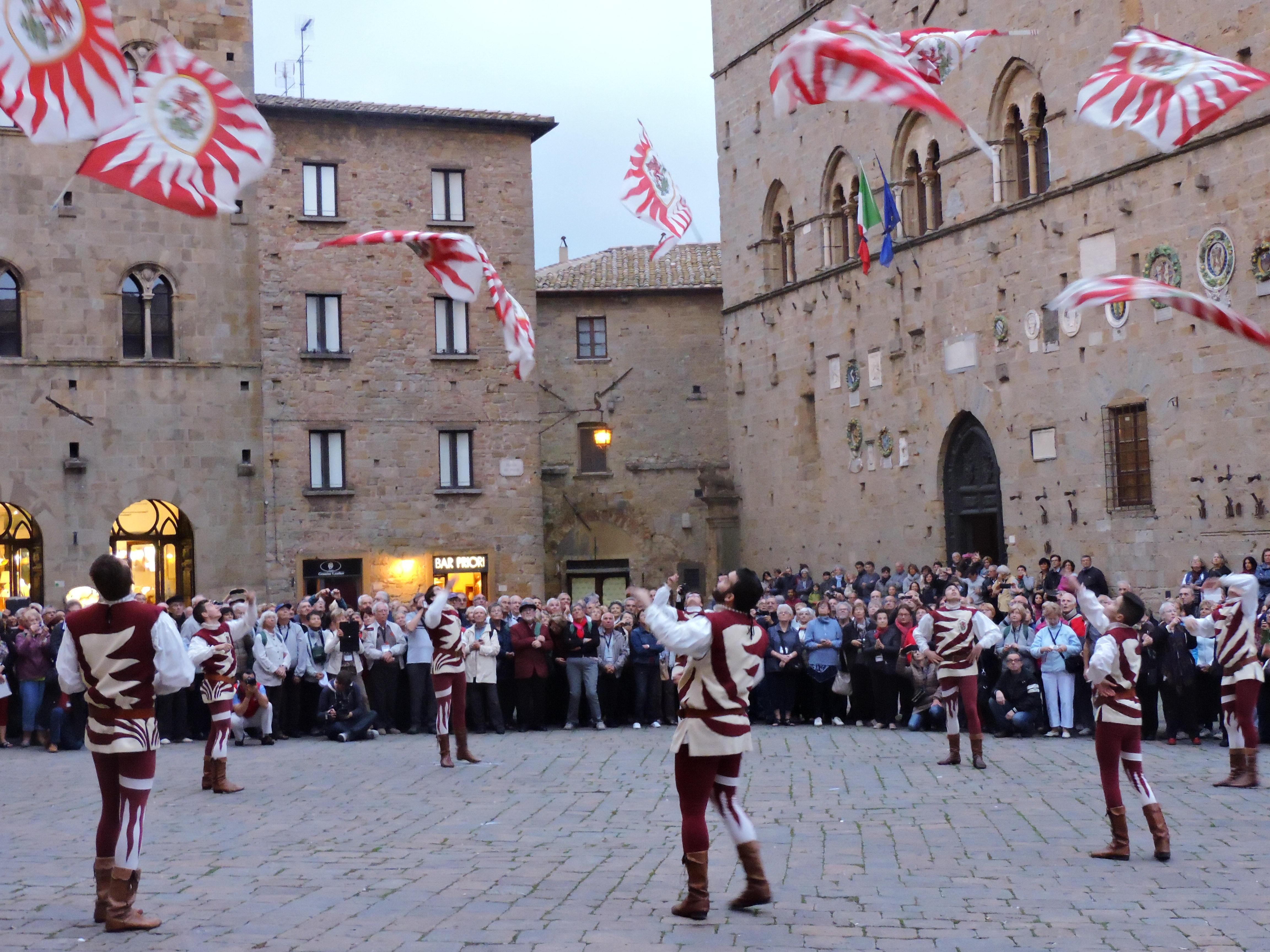 L'esibizione degli sbandieratori di Volterra davanti ai turisti francesi in Piazza dei Priori