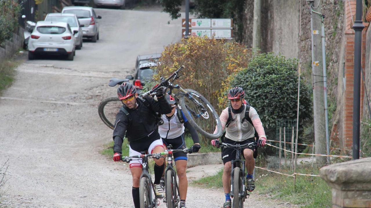 L'incidente alla Valle Benedetta: tre ciclisti portano la bicicletta dell'amico che è caduto ferendosi (Repetti/Pentafoto)