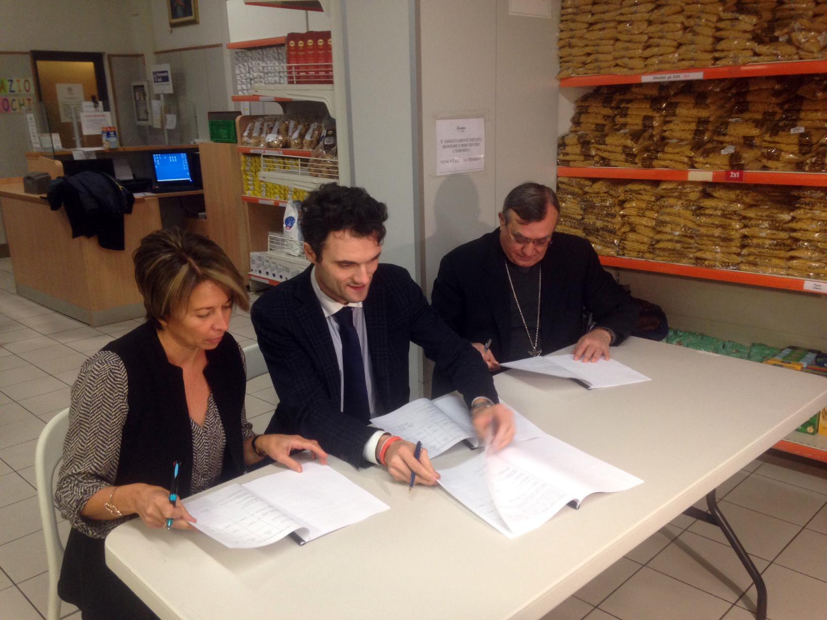 Fabia Romagnoli, il sindaco Matteo Biffoni e il vescovo Franco Agostinelli firmano il protocollo dell'Emporio della solidarietà