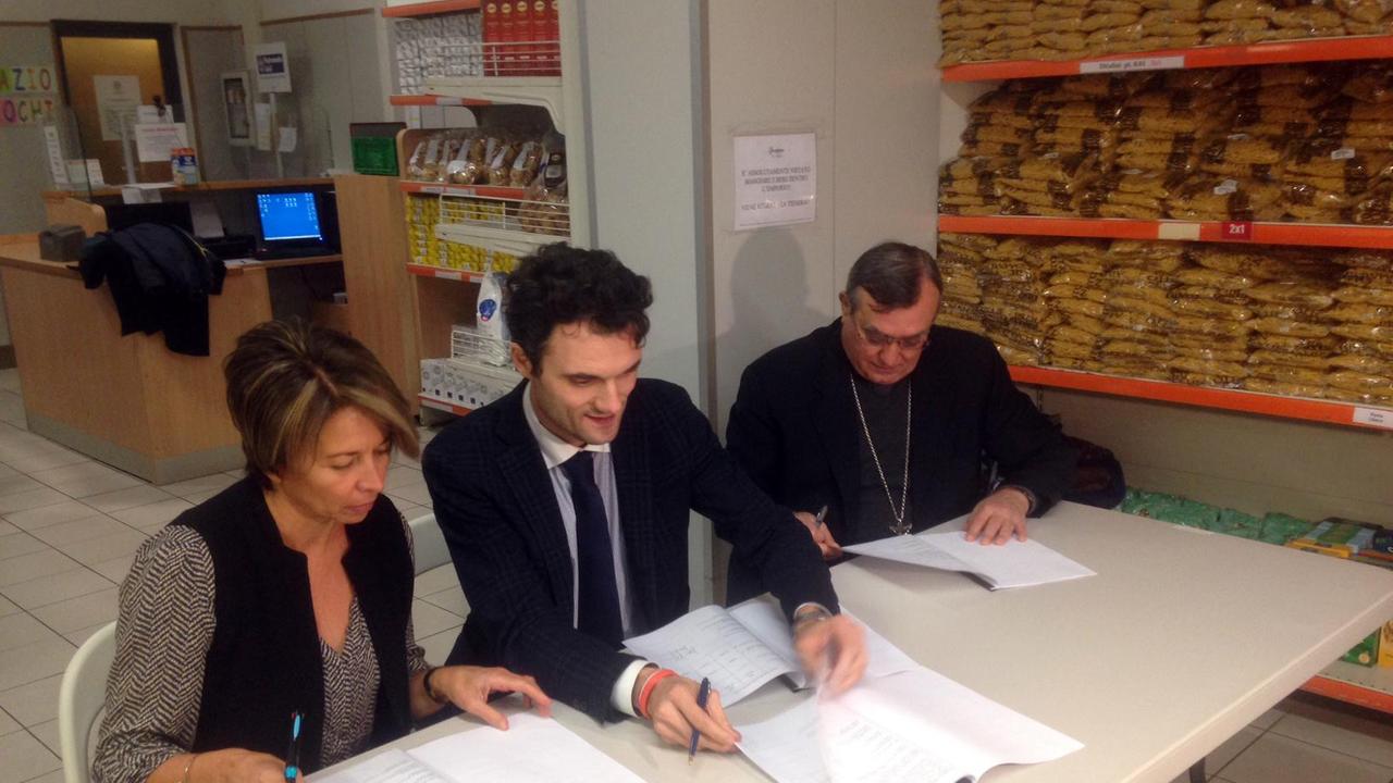 Fabia Romagnoli, il sindaco Matteo Biffoni e il vescovo Franco Agostinelli firmano il protocollo dell'Emporio della solidarietà