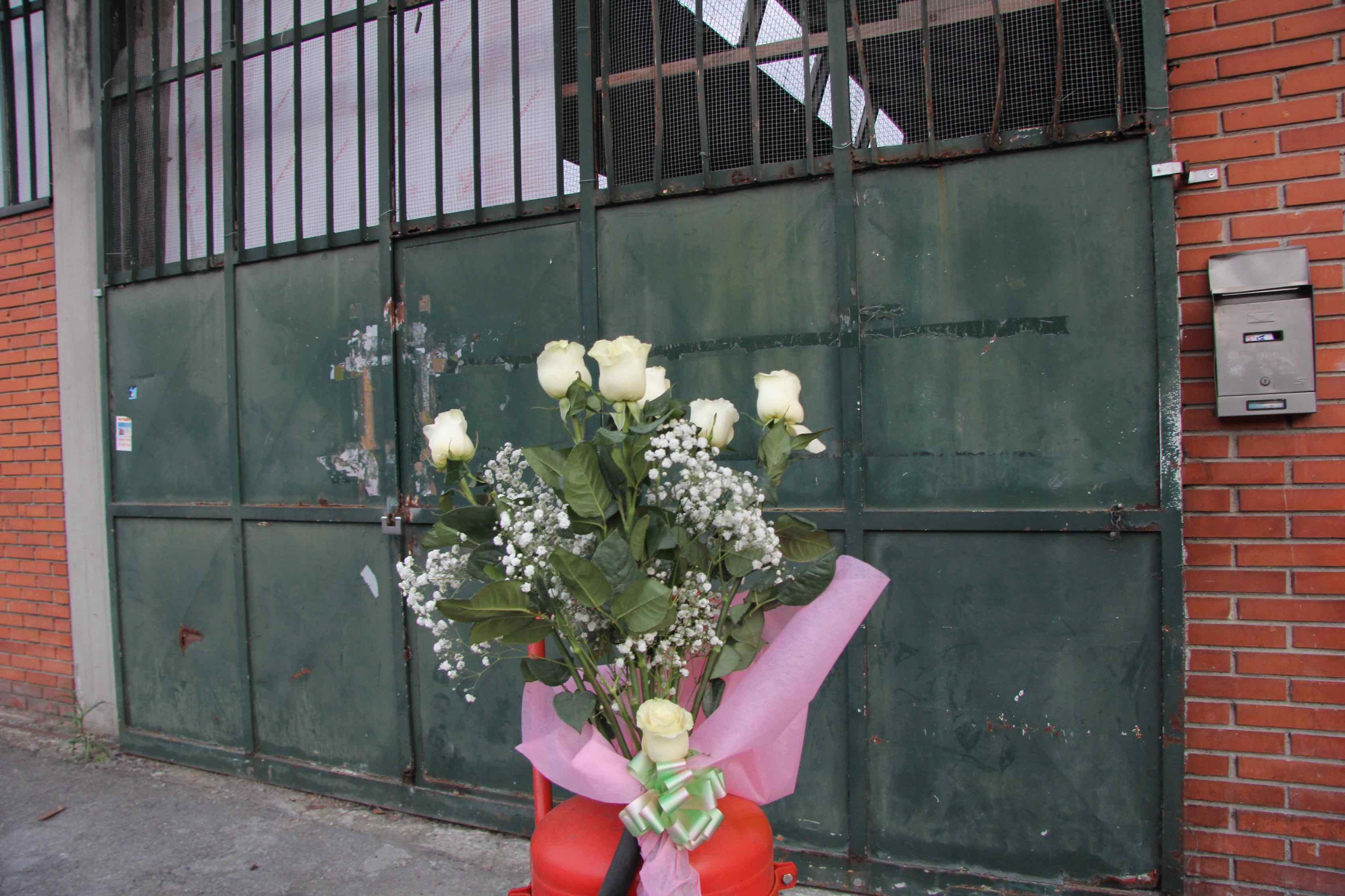 Un mazzo di rose bianche davanti all'ingresso della confezione Teresa Moda