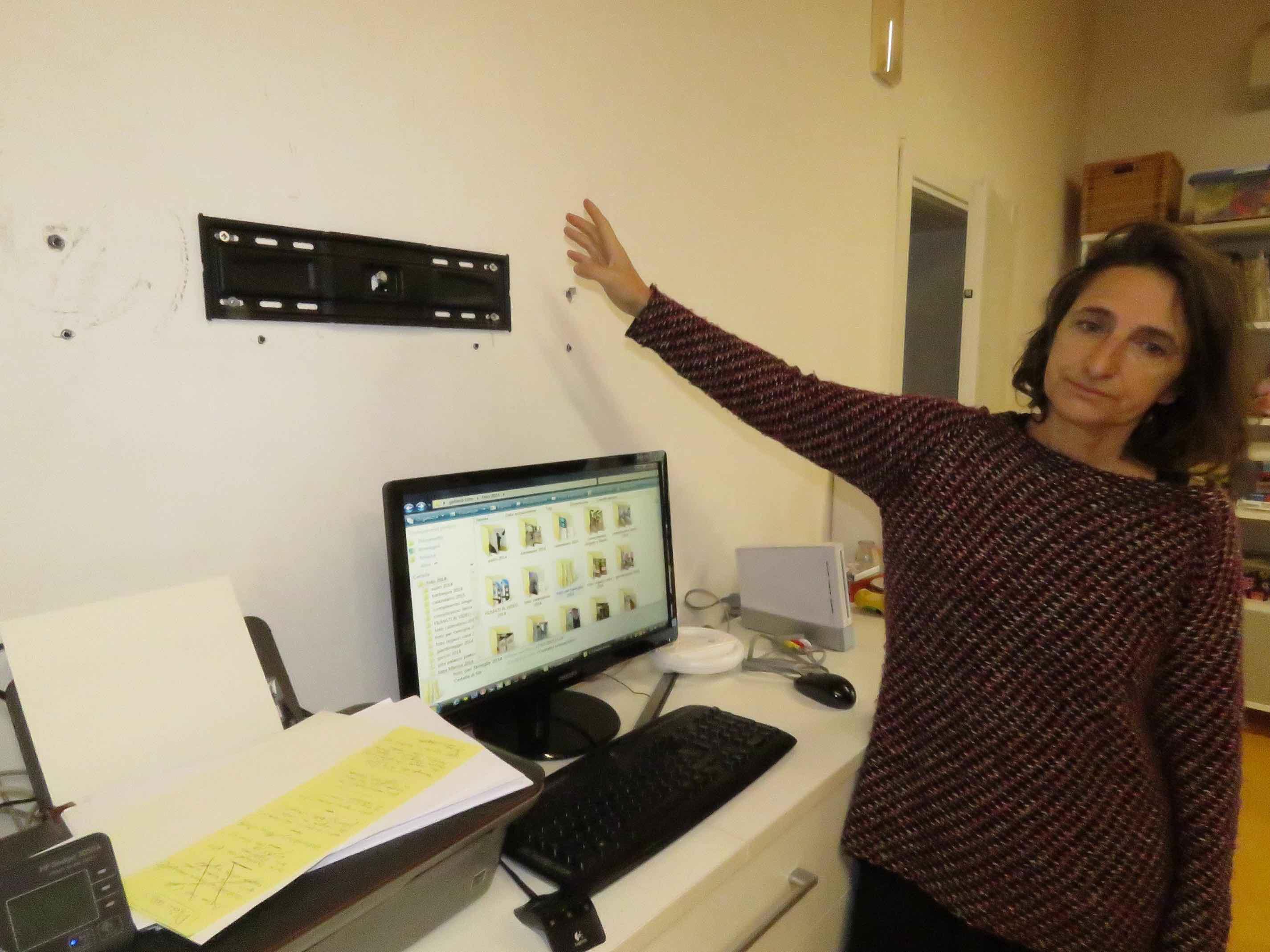 Un'operatrice dell'Oami mostra il punto dove c'era il televisore (foto Batavia) 
