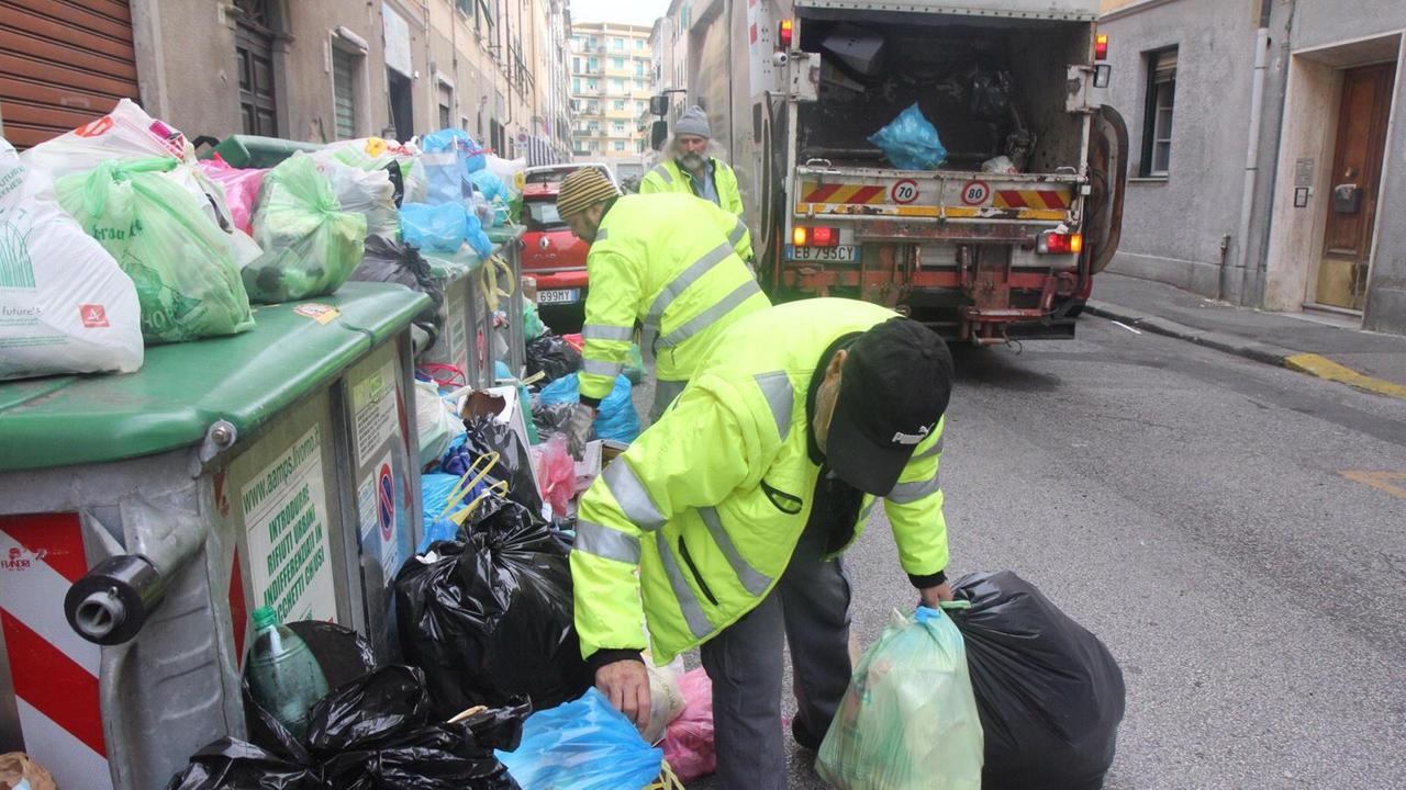 Gli spazzini al lavoro per recuperare la spazzatura ai cassonetti