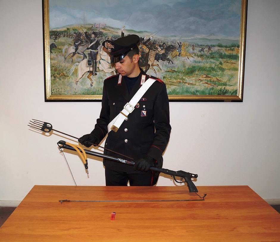 Un carabiniere mostra il fucile da sub usato dall'ucraino