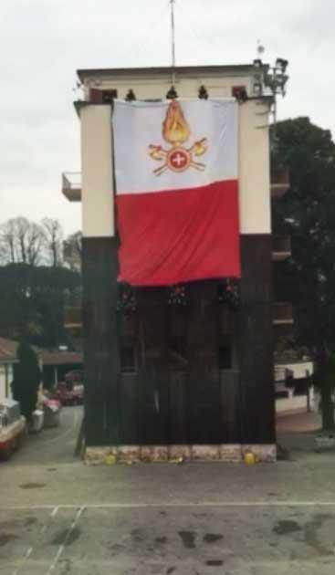 Il momento della scesa della bandiera tricolore da parte di tre vigili del fuoco
