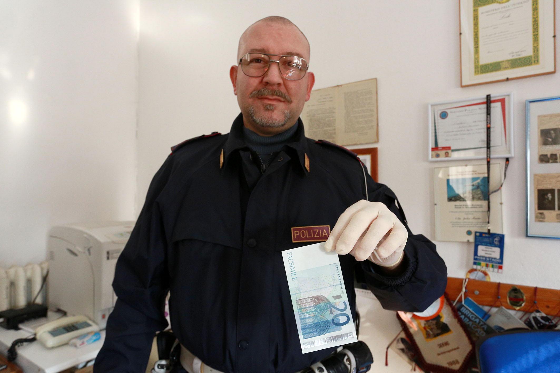 Un poliziotto del commissariato di Empoli mostra una delle banconote false (Foto Agenzia Carlo Sestini)