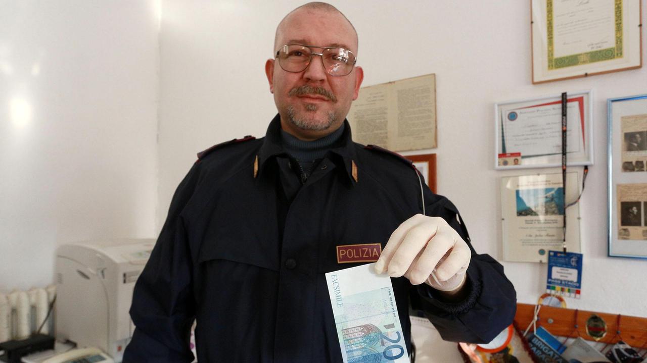 Un poliziotto del commissariato di Empoli mostra una delle banconote false (Foto Agenzia Carlo Sestini)
