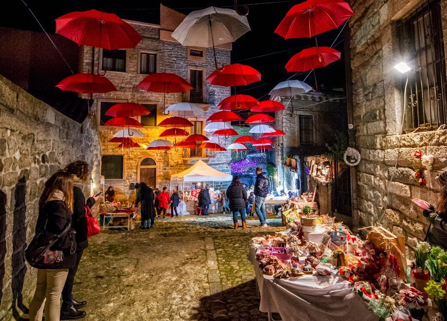 La città si veste di festa tra luci e ombrelli colorati 