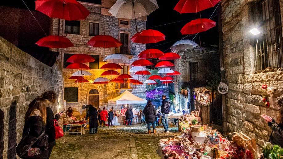La città si veste di festa tra luci e ombrelli colorati