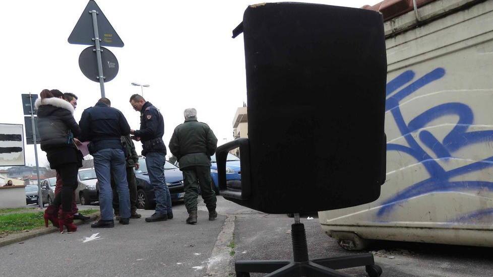La coppia di cinesi, la polizia ambientale (Gav) e gli agenti della Volante, durante la discussione animata, in primo piano la poltrona (foto Batavia)