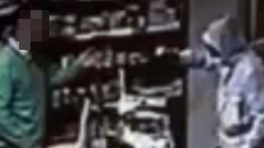 Il bandito minaccia con la pistola il farmacista (scena ripresa dalle telecamere)