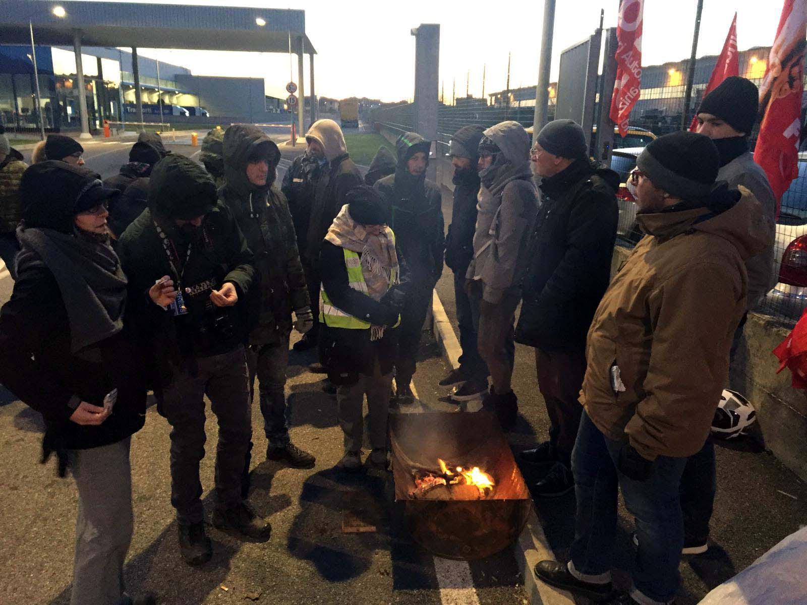 Operai di Ceva e Dna si scaldano al fuoco durante lo sciopero (Foto Franco Silvi)