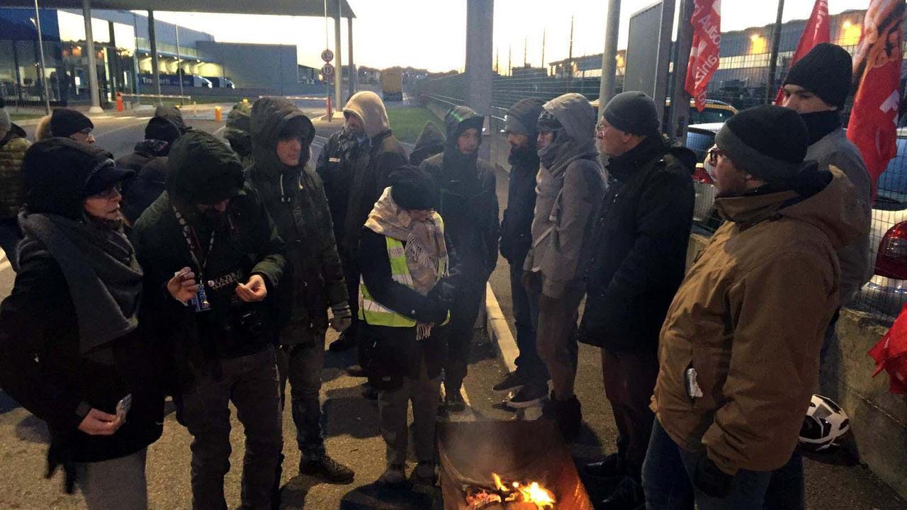 Operai di Ceva e Dna si scaldano al fuoco durante lo sciopero (Foto Franco Silvi)