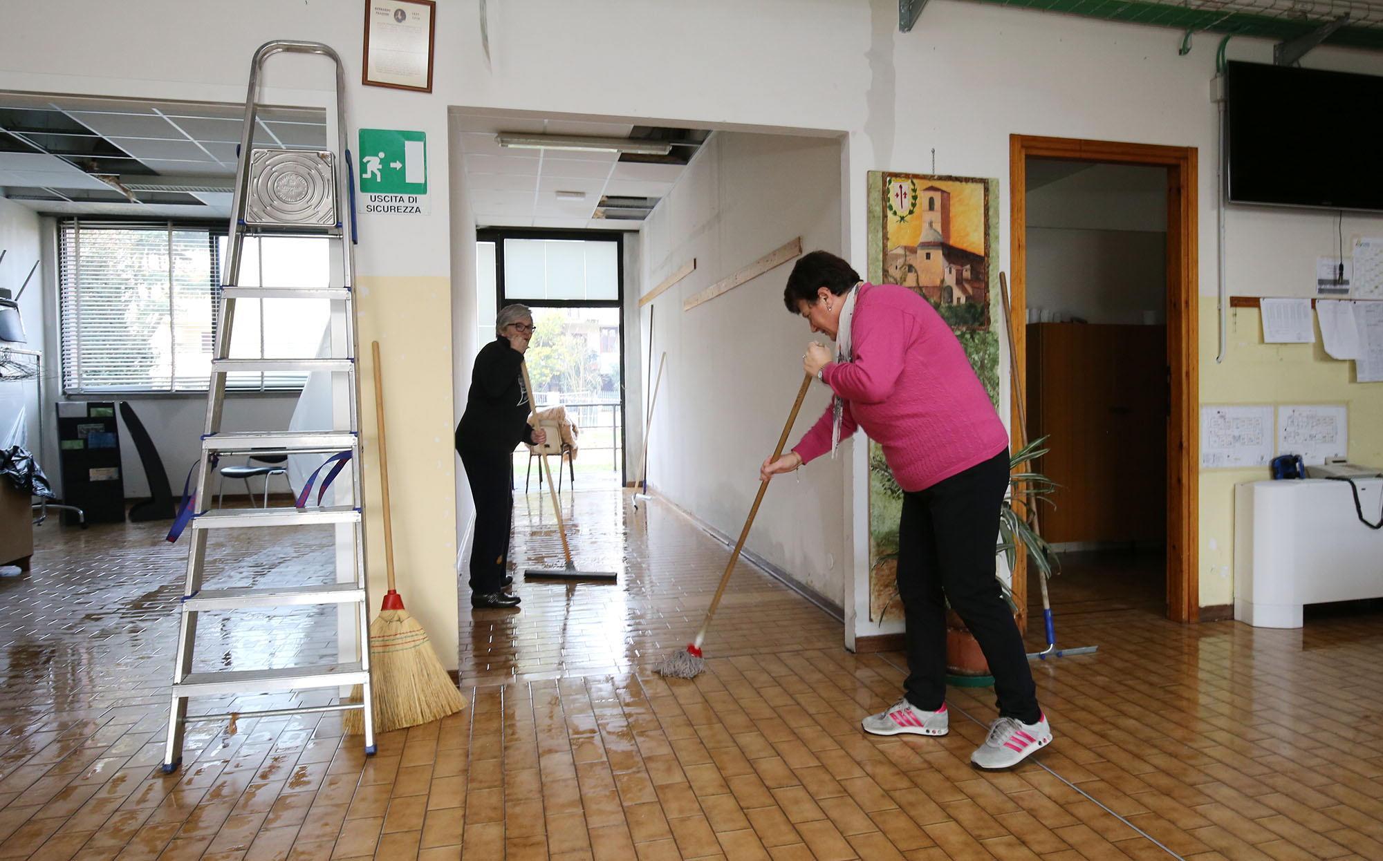 Personale della scuola al lavoro per asciugare il pavimento (foto Nucci)