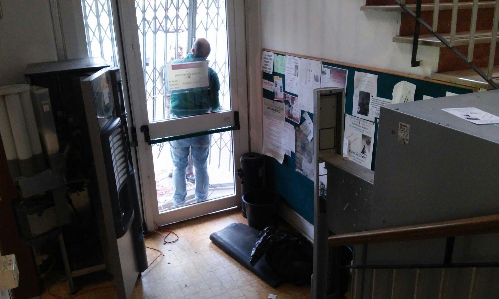 I tecnici controllano i danni alla porta della biblioteca Chelliana manomessa dai ladri. Sulla sinistra il distributore di merendine svaligiato