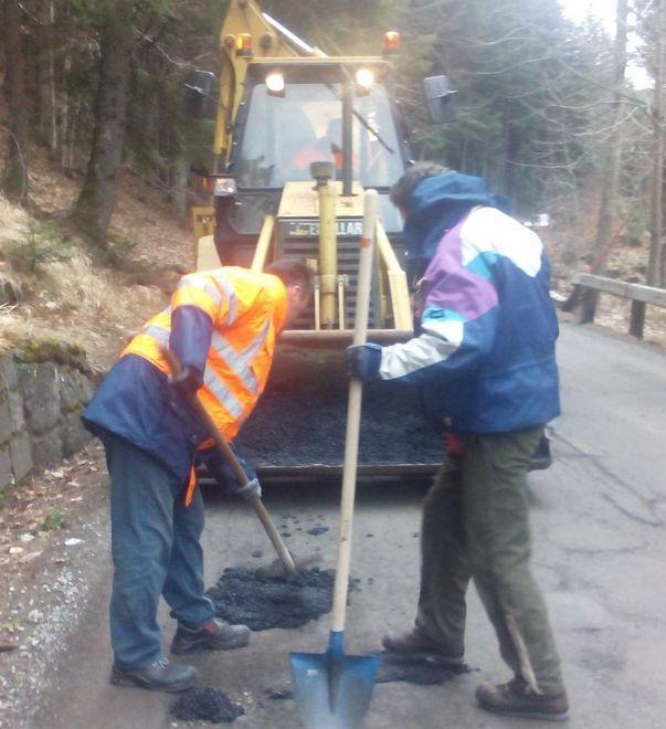 I volontari tappano le buche per ripristinare la strada