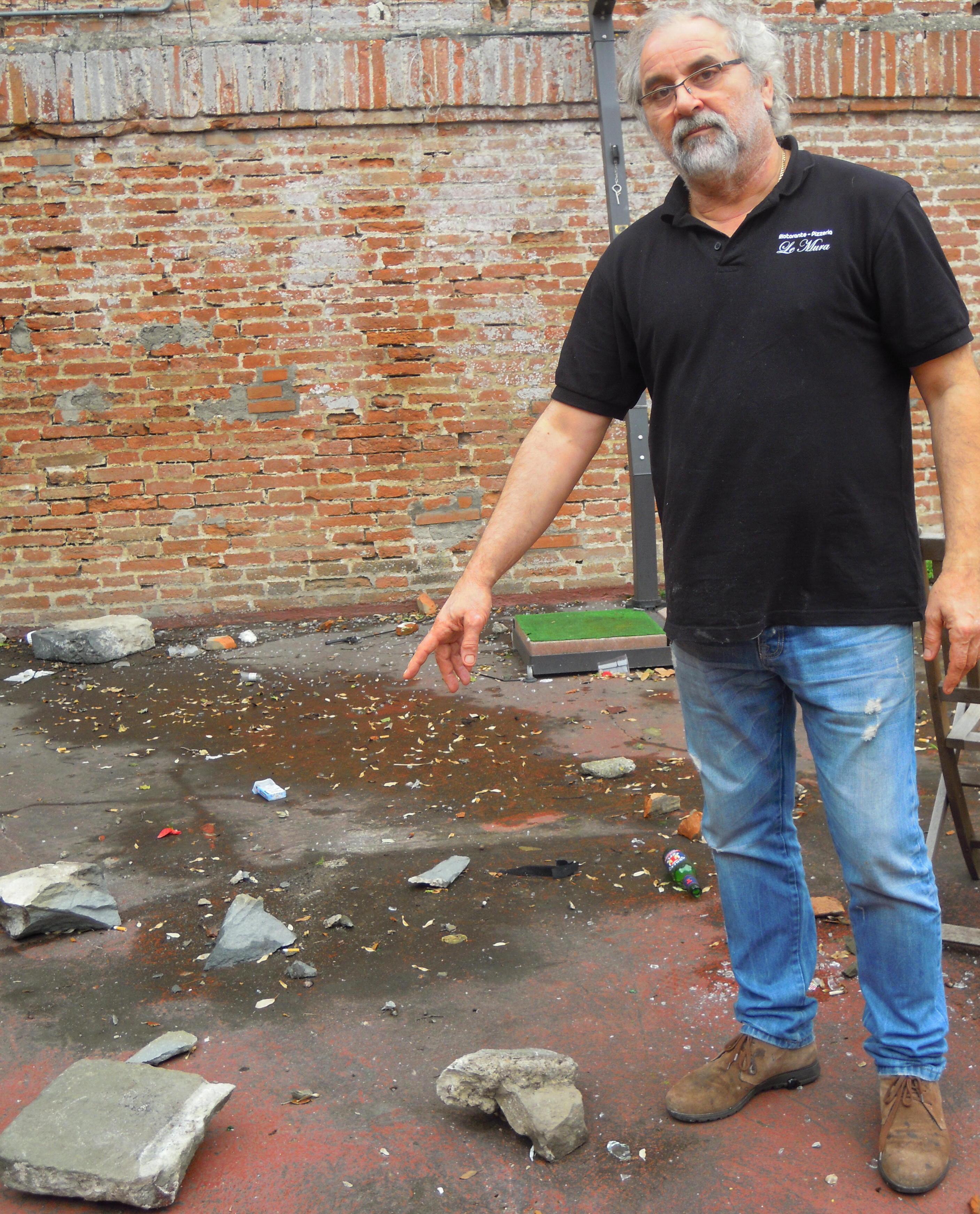 Riccardo Uguzzoni mostra un masso lanciato giù dalle Mura dentro la troniera (foto G.Mezzana) 