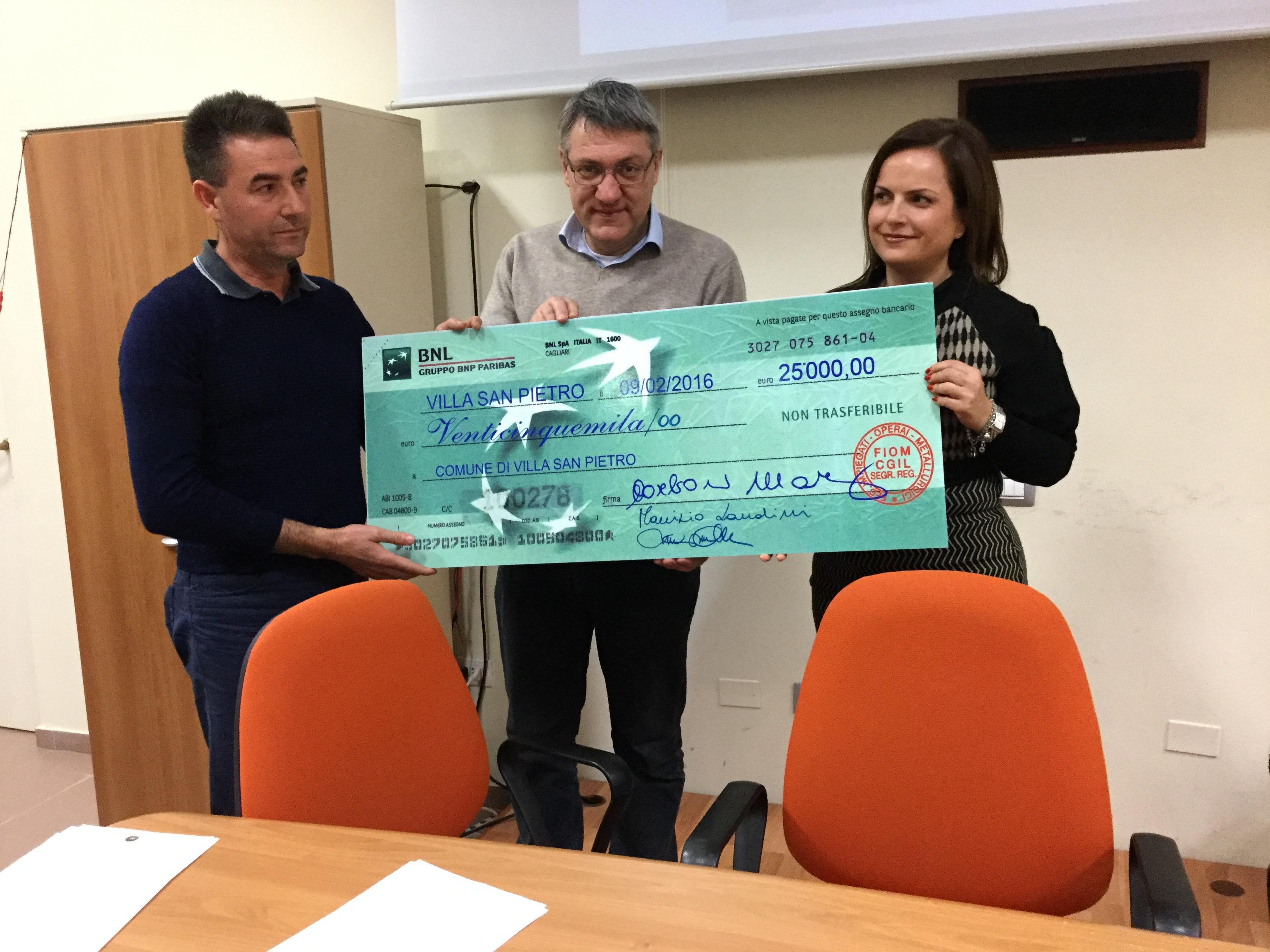 Il segretario nazionale della Fiom Maurizio Landini consegna l'assegno da 25mila euro al sindaco di Villa San Pietro, Marina Madeddu