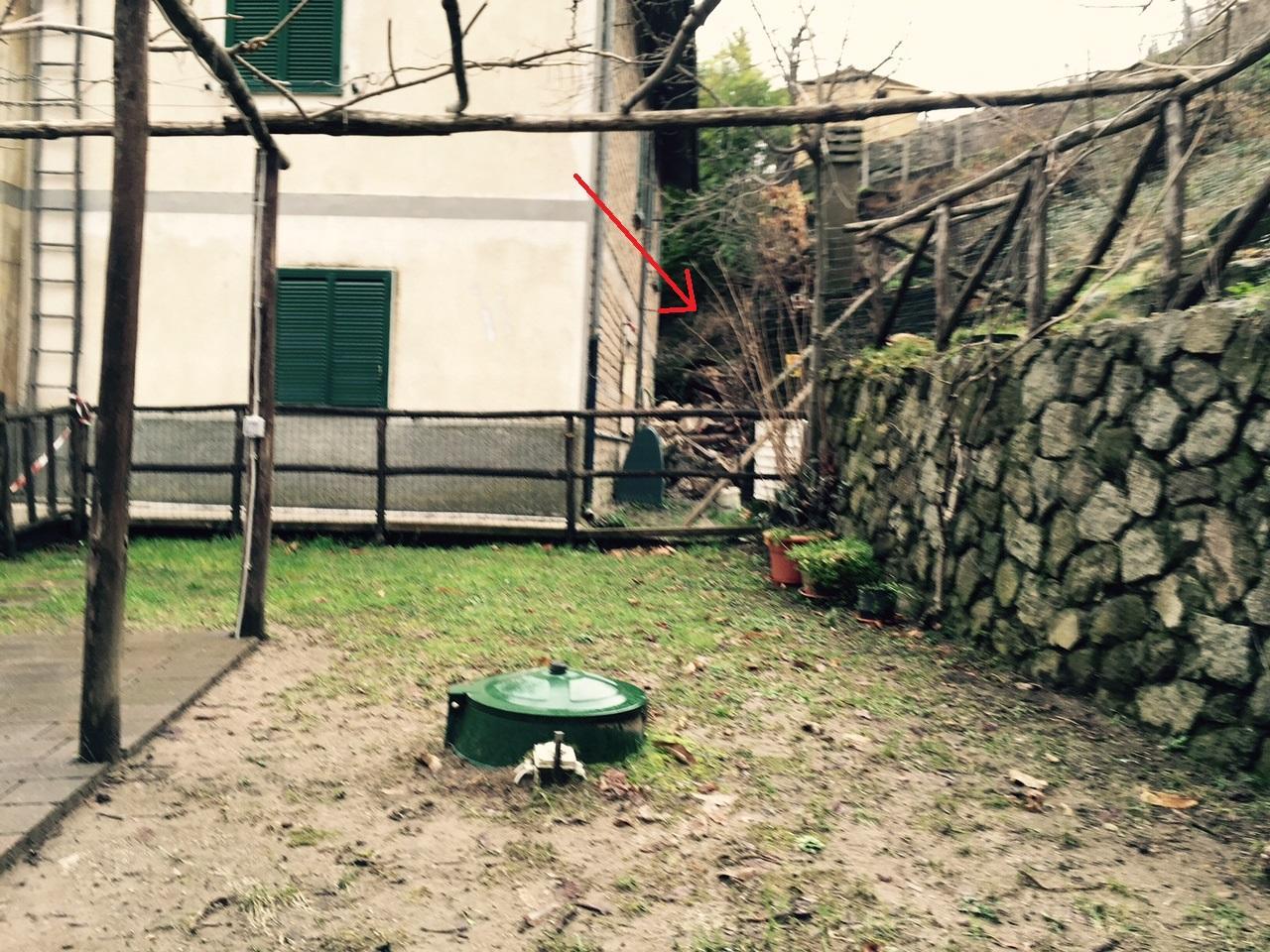 La freccia indica la frana nel retro della casa di Bagnolo (Santa Fiora)