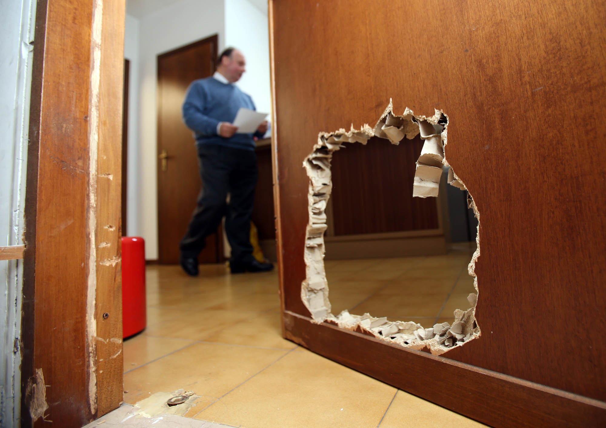 La porta dell'agenzia di assicurazioni sfodnata dai ladri (Foto Nucci)